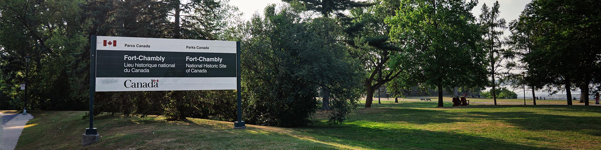 Official Parks Canada poster showing the location of Fort Chambly National Historic Site, with the lush park and the late afternoon light in the background.