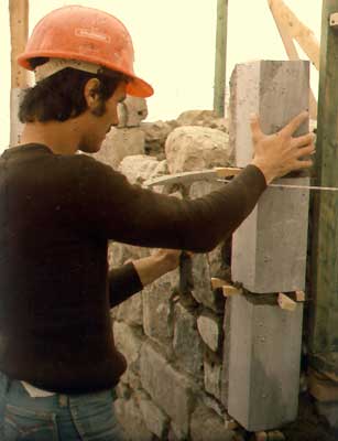 Un maçon reconstituant un des murs de pierre de la forteresse