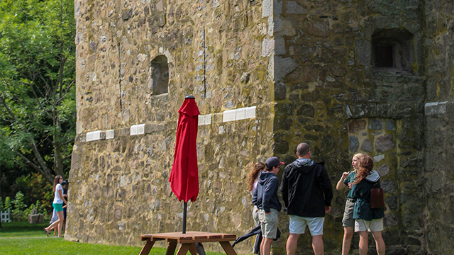 A Parks Canada's female guide gives a detailed explanation of the stone fort during a group tour of Fort Chambly National Historic Site.