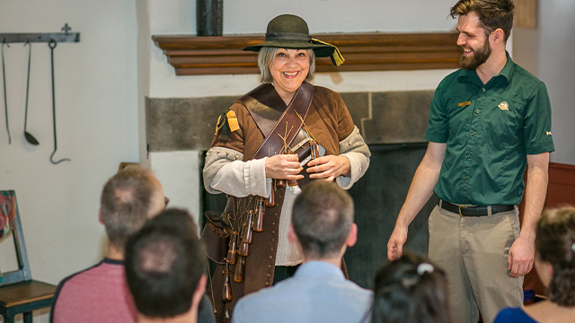 Parks Canada's female and male guides give detailed explanations of a soldier's military uniform during a group activity at Fort Chambly National Historic Site.