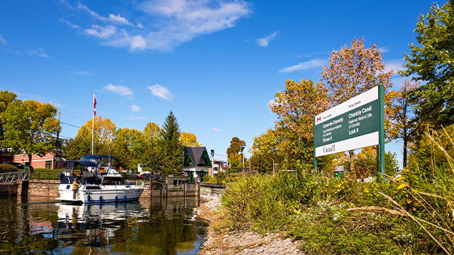 Autumn landscape and view of Lock No. 9 of the Chambly Canal National Historic Site, located in Saint-Jean-sur-Richelieu, and a recreational craft arriving from Lake Champlain via the Richelieu River.