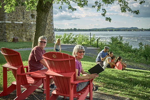Two red chairs in front of the Chambly rapids and basin