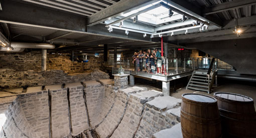 Visite des forts et châteaux Saint-Louis par un guide à un groupe de visiteurs à proximité de la glacière.