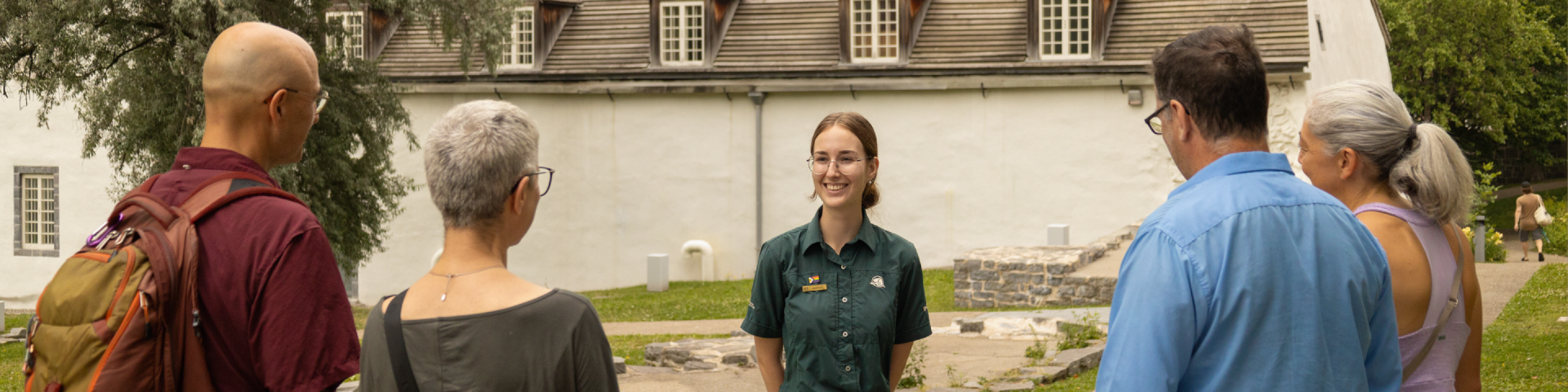 Un guide échange avec quatre visiteurs devant la redoute Dauphine.