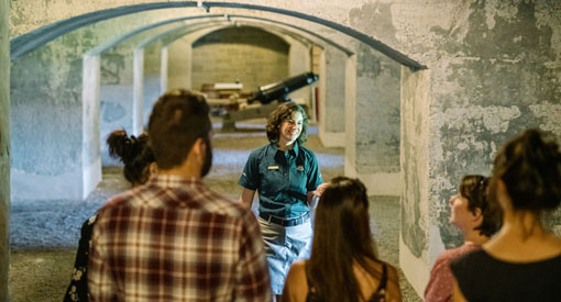 Un guide de Parcs Canada présente la casemate 24 à un groupe de visiteurs.