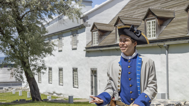 A guide dressed as a French soldier poses in front of the Dauphine redoubt.