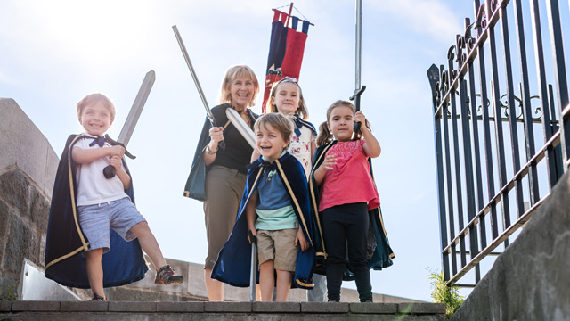 Quatre enfants costumés en chevalier et une grand-mère sur les fortifications de Québec.