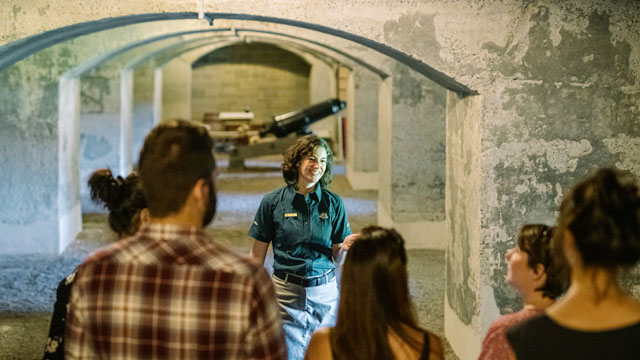 A Parks Canada guide interprets Casemate 24 for a group of visitors.