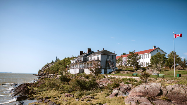 Vue des hôtels de 2e et de 3e classe et de la croix celtique à partir du quai à Grosse-Île.