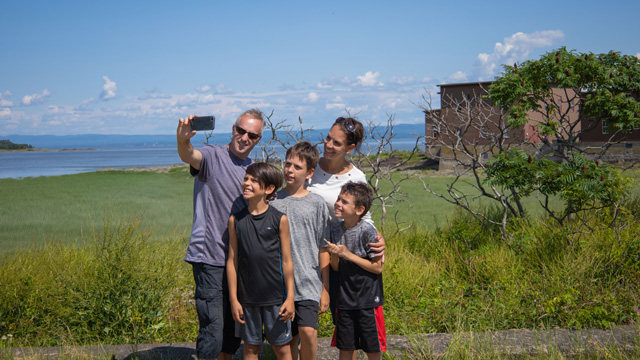Une famille se photographie en face de la Baie de l'hôpital.