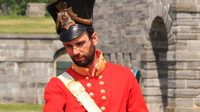 Un guide du lieu historique national du Fort-Lennox est déguisé en soldat britannique dans le cadre d’une activité présentée aux visiteurs.