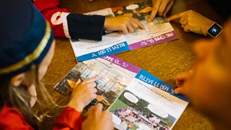 Children dressed as British soldiers fill out their Xplorers notebooks.