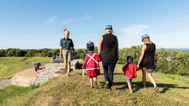 Deux mères et deux enfants avec une guide de Parcs Canada au lieu historique national des Forts-de-Lévis