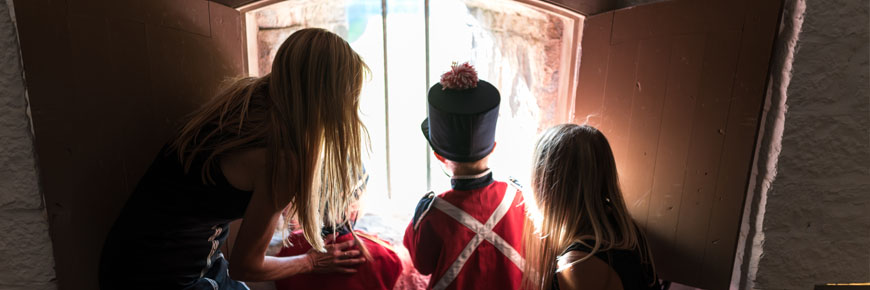 une famille visite regarde à travers une fenêtre au fort numéro-un