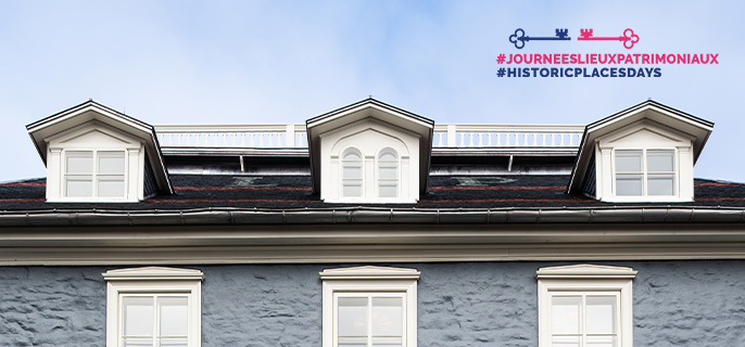 View of the roof and dormers of the Manoir Papineau National Historic Site against a blue sky background.