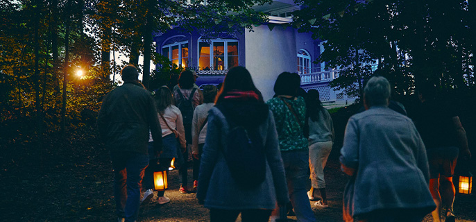 Des visiteurs participent à une visite guidée nocturne au lieu historique national du Manoir-Papineau.
