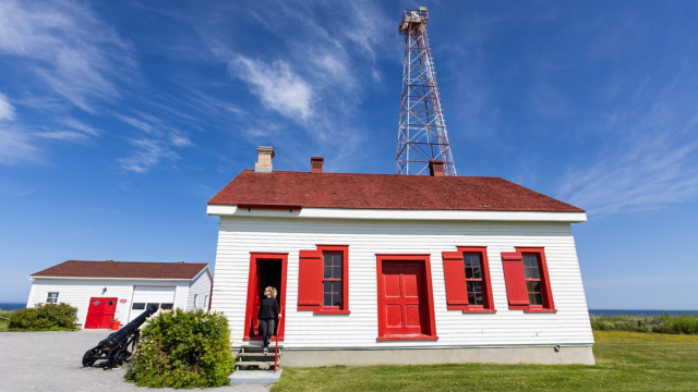 Une visiteuse entre dans un bâtiment de la station de phare de Pointe-au-Père.