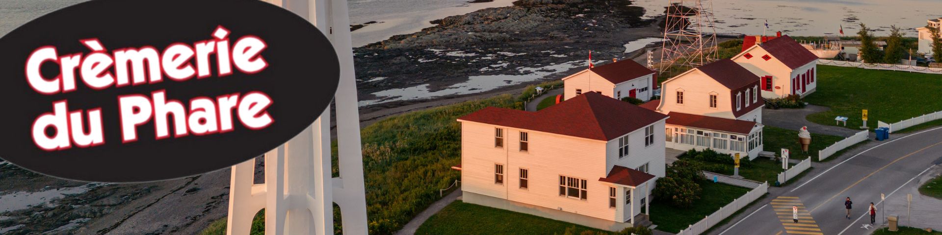 Aerial view of a lighthouse and its dwellings at sunset.