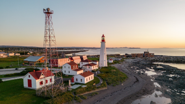 Aerial view of Pointe-au-Père lighthouse historic site at sunset.