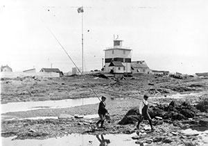 Black and white picture. A building and two boys playing in front