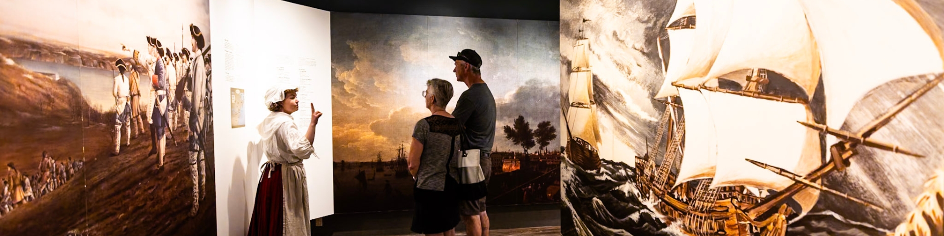 Two persons stand in front of an exhibit board. 