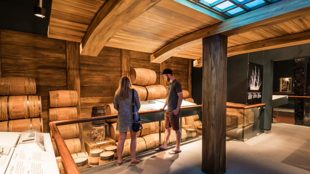 Two visitors in an exhibit showing a cargo.   