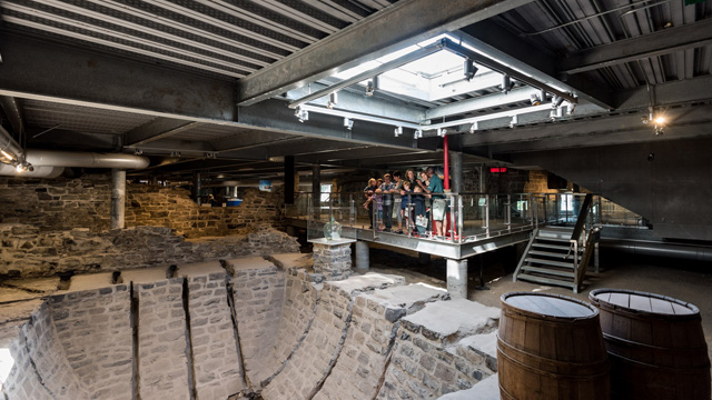 A group of visitors with a Parks Canada guide look at the ice box.