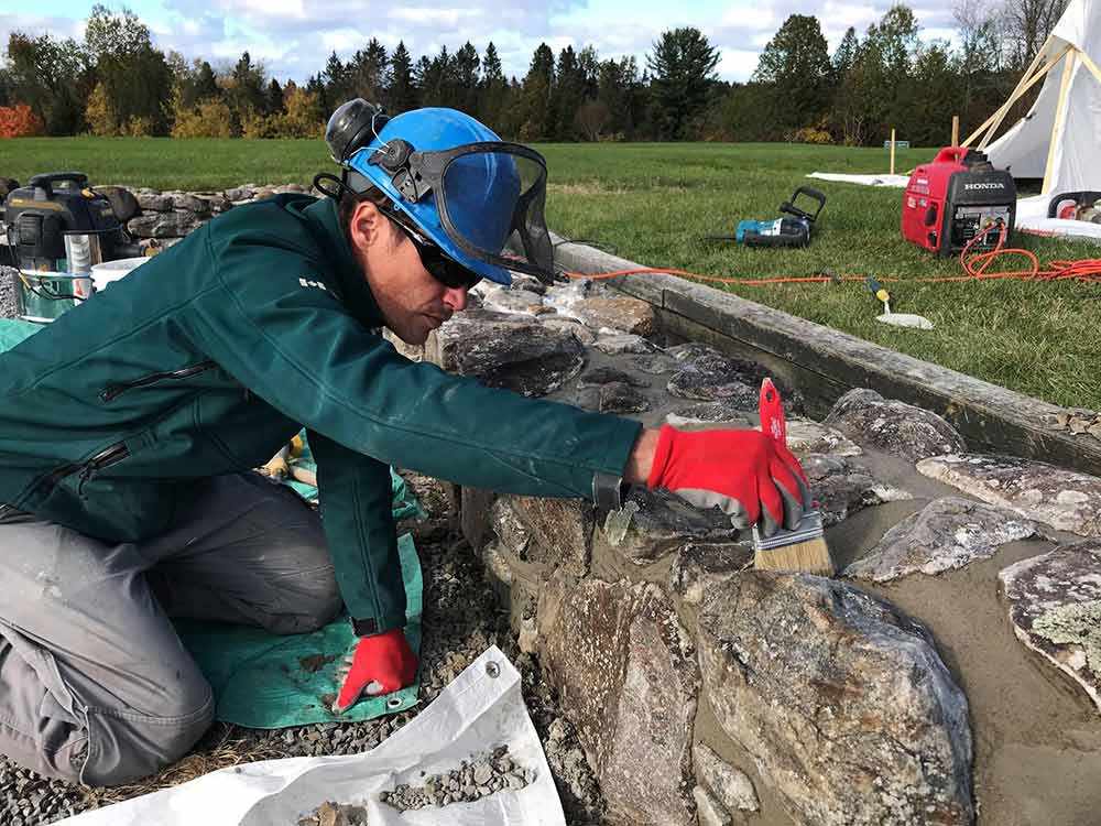 A worker repointing the remains of old foundations