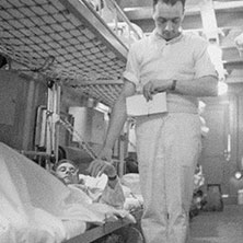 Un aide-soignant prend le pouls d’un soldat à bord du navire-hôpital <em>Lady Nelson</em> en janvier 1944.