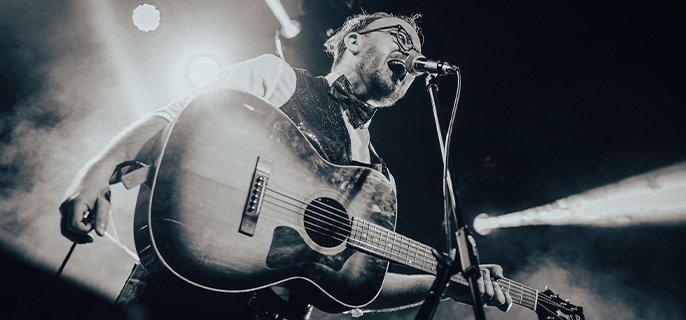 Le guitariste et chanteur du groupe de musique rock and roll The Singles en pleine performance musicale.