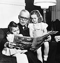 St-Laurent faisant la lecture à deux de ses petites-filles, Marie et Francine