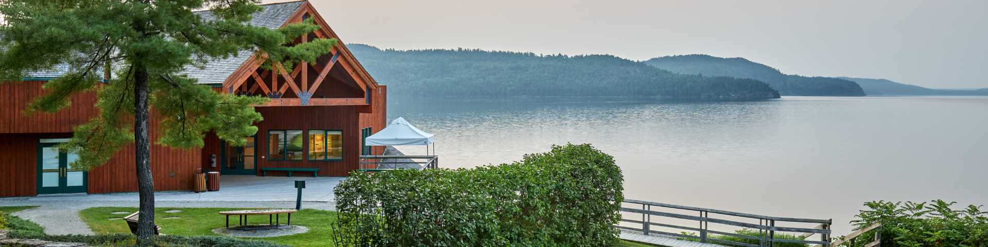 Vue du pavillon d’accueil du lieu historique avec le lac et les collines en arrière-scène.