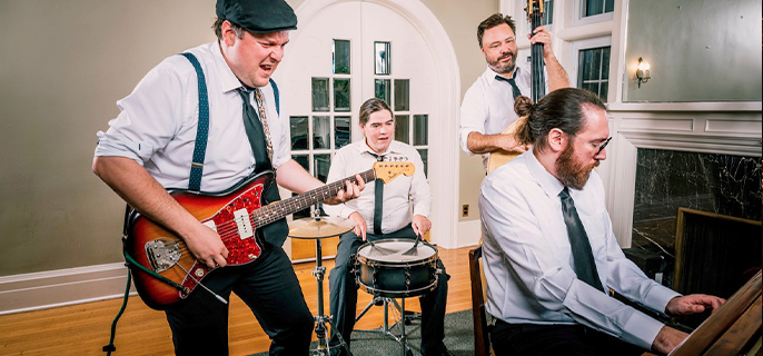 Le quatuor Parle Parle Jazz Jazz, un ensemble musical formé des musiciens abitibiens Benoît Lavergne, Francis Courtois, Joël Polard-Perron et Jean-Philippe Rioux-Blanchette, en train de jouer de la guitare, du piano, de la caisse claire et de la contrebasse.