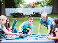 Cinq enfants réalise un casse-tête.