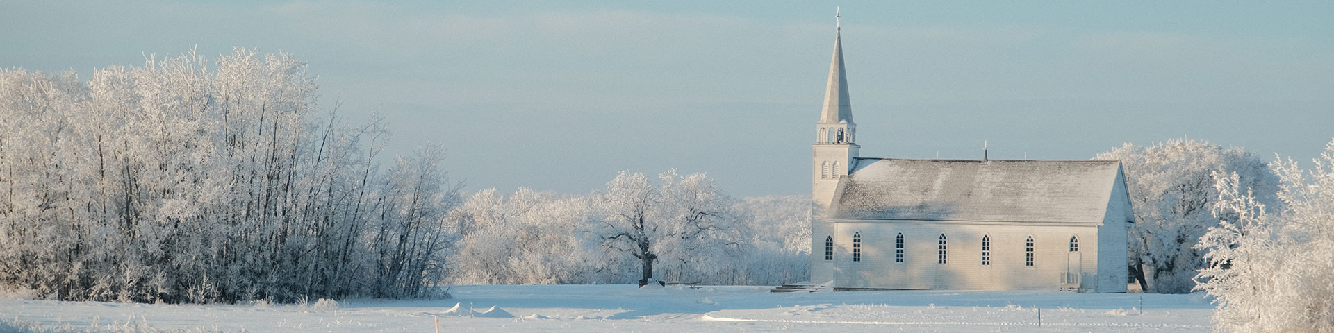 Church at Batoche National Historic Site surrounded by trees on a winter day.