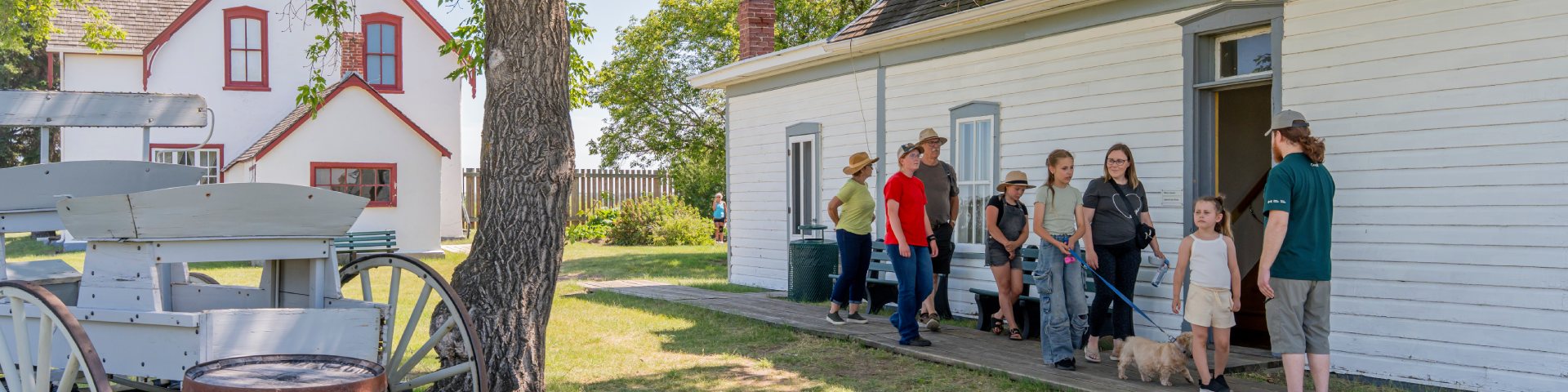 A Parks Canada interpreter leads a group of visitors on a tour along the boardwalk outside the Officer’s Quarters.
