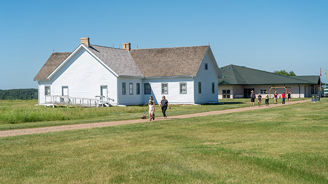 A group of visitors walk along the pathway by Barracks #5. 