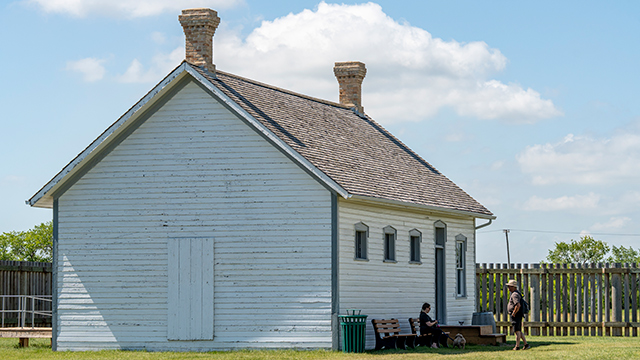 Two visitors in front of the Guardhouse inside the fort.  