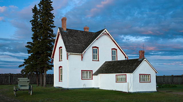 The Commanding Officer’s Residence against a blue sky with tinges of pink at sunset. 