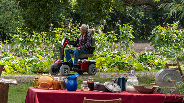 Un visiteur utilisant un scooter sur un sentier près du jardin.
