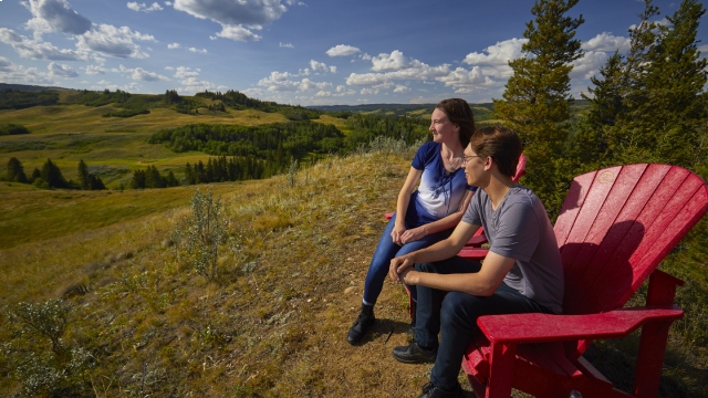 Two visitors sitting on red chair