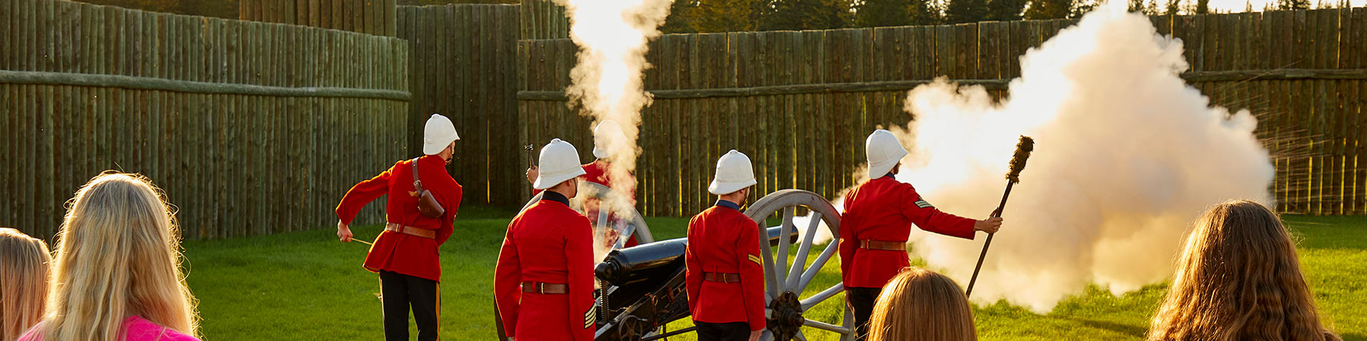 Visitors watch a demonstration of a cannon at Fort Walsh National Historic Site.