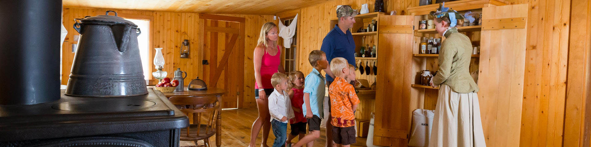 Visitors explore inside one of the historic buildings with a costumed interpreter, at Fort Walsh National Historic Site.