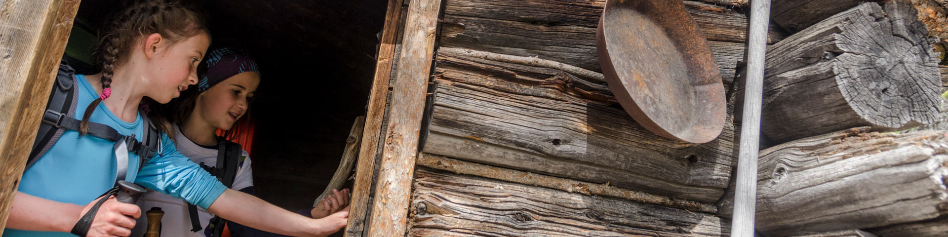 Two children exploring old gold rush cabin on Chilkoot Trail