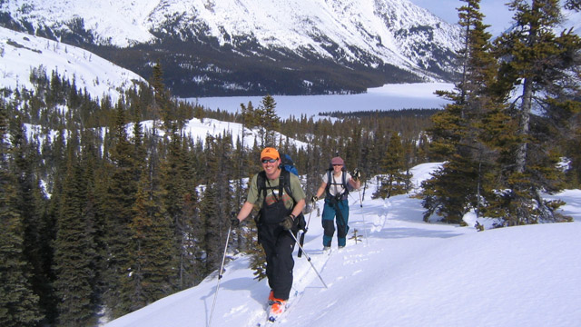 Deux skieurs heureux en escaladant une colline.