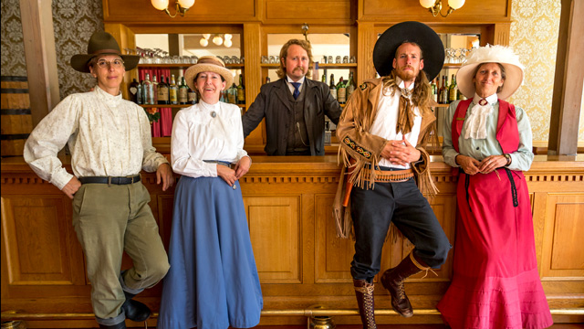 Des guides en costume historique se penchent sur le bar