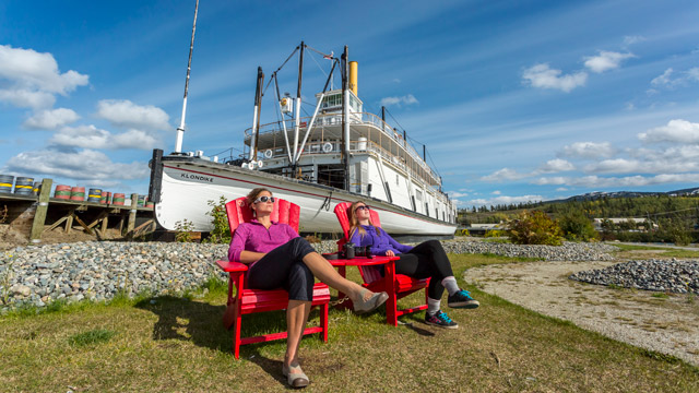 Les visiteurs apprécient les chaises rouges au lieu historique national S.S. Klondike