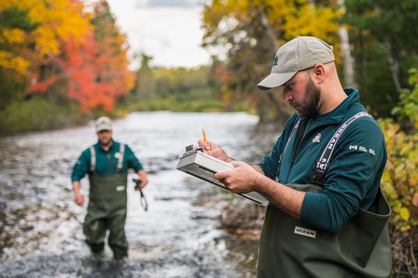 Resource conservation staff taking measurements in the river in Kouchibouguac National Park