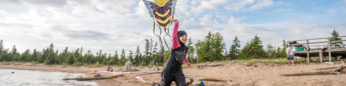 Girl playing with kite at Horseshoe Beach. Pukaskwa National Park