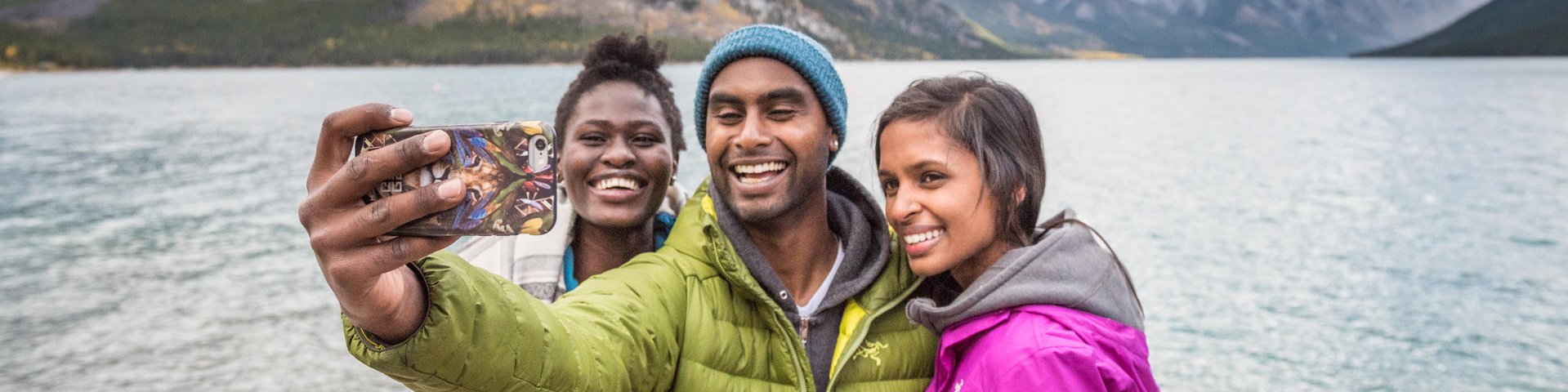  A couple of millennials take a selfie on the shores of Lake Minnewanka. Banff National Park.